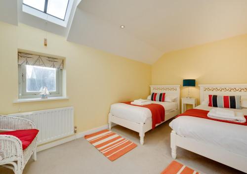 AldringhamWest Barn Cottage的一间卧室设有两张床和窗户。