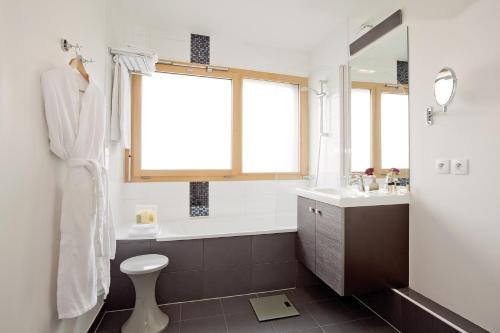 伊西莱穆利诺巴黎瑞熙侗伊西莱斯利诺酒店的带浴缸、卫生间和盥洗盆的浴室