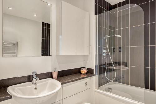 伦敦Delightful Apartment Wandsworth的白色的浴室设有水槽和淋浴。