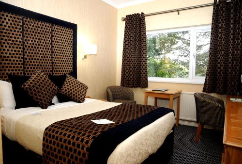罗瑟勒姆Carlton Park Hotel Rotherham的酒店客房设有床和窗户。