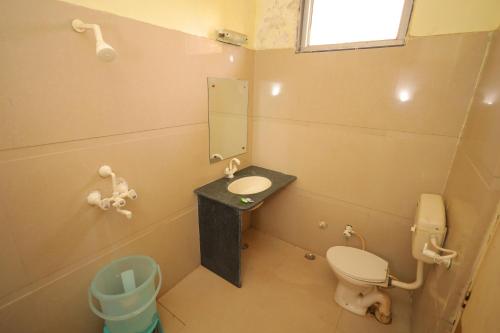 马图拉Hotel Mukund Priya- Near Krishna Janam Bhoomi的一间带卫生间、水槽和镜子的浴室