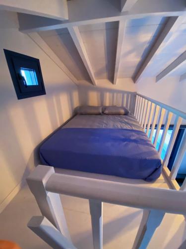 VagiaNikoli House的一间带一张床铺的卧室,位于带天花板的房间内
