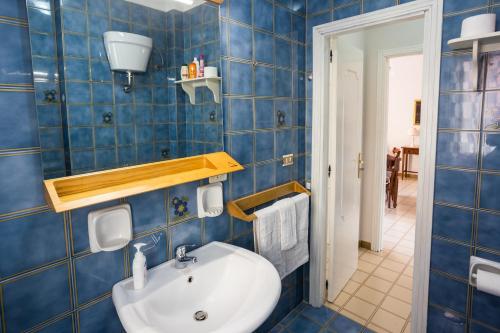 斯卡莱阿Gilda’s Home的浴室配有水槽和蓝色瓷砖墙。