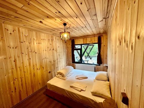 贾马里海姆森TUVA VİLLA Bungalov的木制客房内的一间卧室,配有一张床