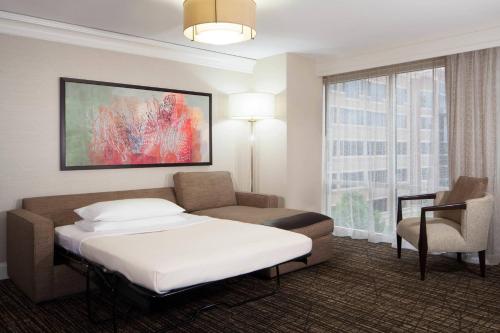 舒格兰Houston Marriott Sugar Land的配有一张床和一把椅子的酒店客房
