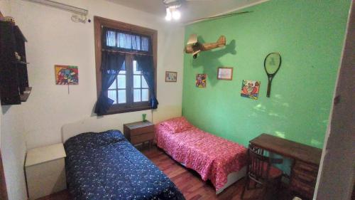 富内斯Casa Funes的绿色的客房设有床和窗户。