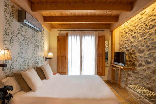 帕劳·萨巴尔德拉Hotel Boutique Niu de Sol - Designed for Adults的一间卧室设有一张大床和一个窗户。