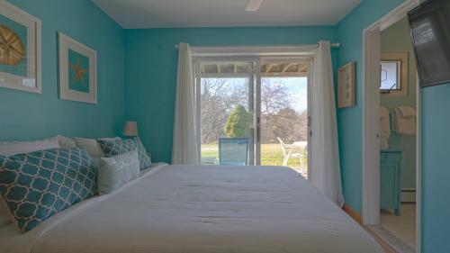 阿默甘西特阿玛甘赛特海洋沙丘公寓的蓝色的卧室设有一张大床和一个窗户