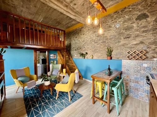 蓬塔杜帕戈Victoria Tiny Stone House的客厅配有木桌和黄色椅子