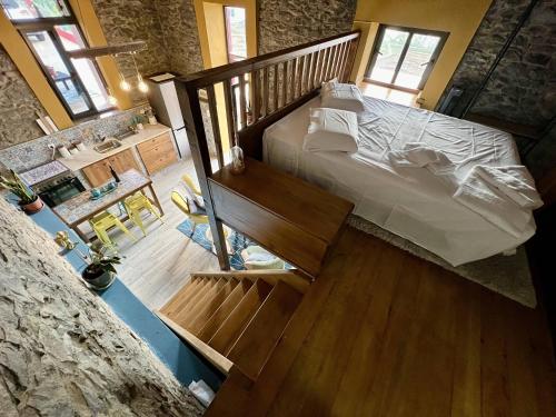 蓬塔杜帕戈Victoria Tiny Stone House的一间带大床和楼梯的卧室