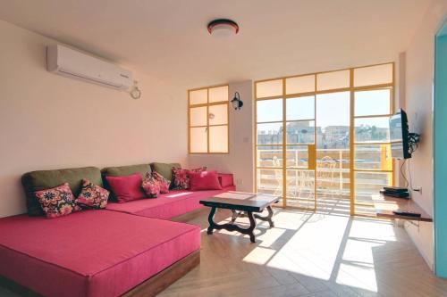 耶路撒冷戈尔道度假租赁公寓的客厅配有粉红色的沙发和桌子