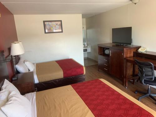雷丁King's Inn Motel的酒店客房设有两张床、一张桌子和一台电视。
