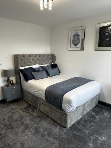 斯劳Two bed apartment with balcony Slough,Windsor,Legoland的一间卧室配有一张带蓝色枕头的大床