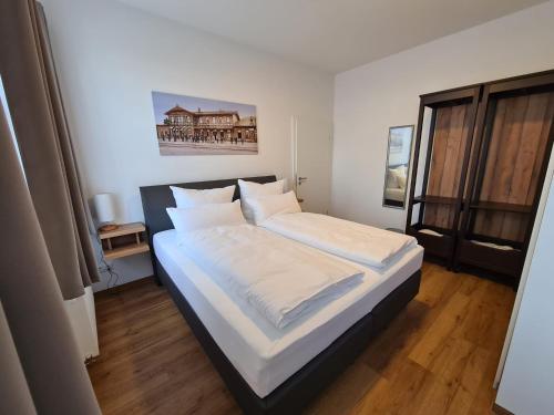 耶拿Hotel Gleis 3viertel Jena的一间卧室配有一张带白色床单的大床
