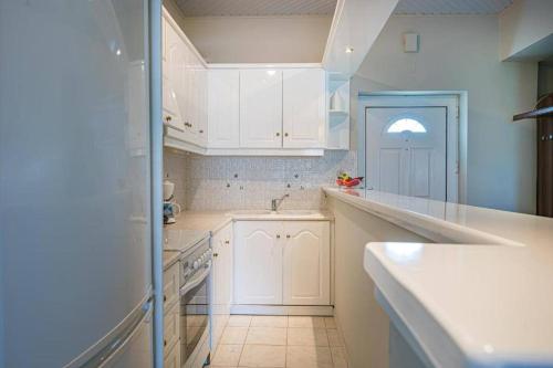 PsarouKrystalia's house的厨房配有白色橱柜和水槽