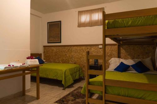 帕拉卡斯BUGANVILIA的一间卧室配有两张双层床和一张书桌
