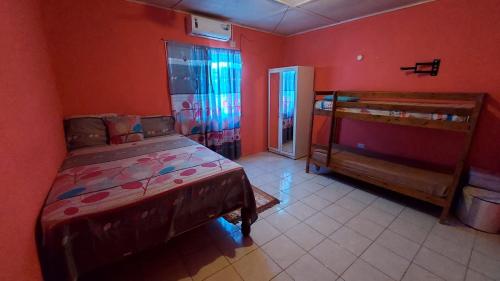 BelfastCharming 1-Bedroom House in St Thomas Jamaica的卧室设有红色的墙壁、一张床和门廊