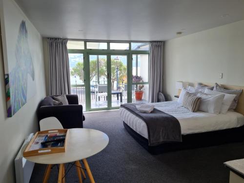 阿卡罗阿The Wharf Seaview Apartments by AVI的酒店客房设有一张大床和一张桌子。