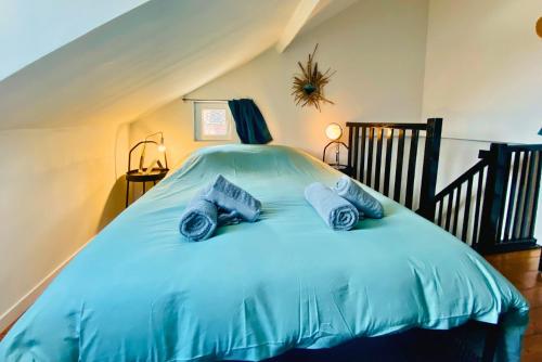 鲁昂La Maison des Plantes, charmante, atypique et cosy pour 4 personnes avec parking et jardin的一间卧室配有一张带蓝色床单和枕头的床。