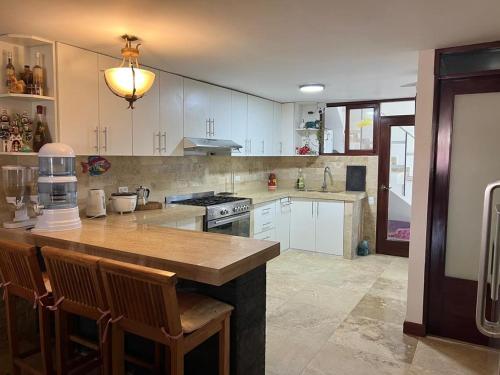 皮斯科Casa Villa Victoria en Pisco的厨房配有白色橱柜和木制台面