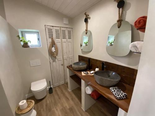 Octeville-sur-MerEntre Honfleur et Etretat的一间带两个盥洗盆、卫生间和镜子的浴室