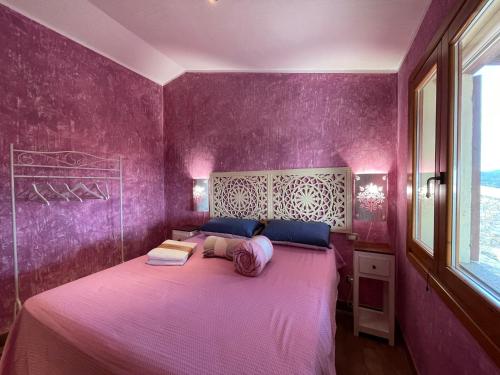 帕拉迪索海岸Villa Rocce Rosse的紫色卧室设有一张带紫色墙壁的大床