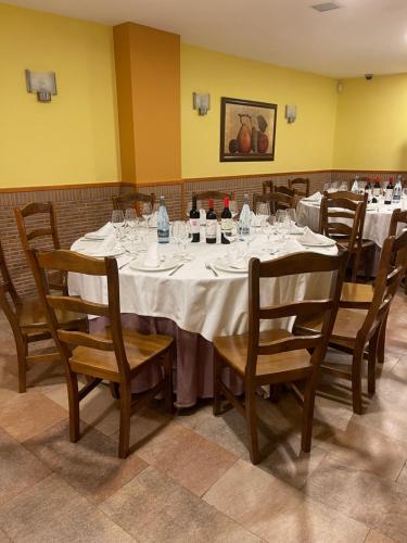 PomarEL RINCON DE TOÑO的用餐室配有带葡萄酒瓶和椅子的桌子