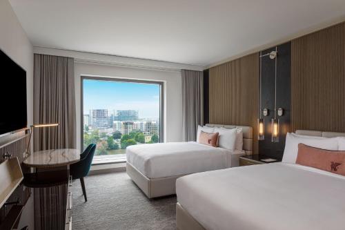夏洛特JW Marriott Charlotte的酒店客房设有两张床和大窗户。
