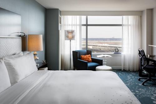 阿林顿阿灵顿首府美景万丽酒店的酒店的客房 - 带一张床、椅子和窗户