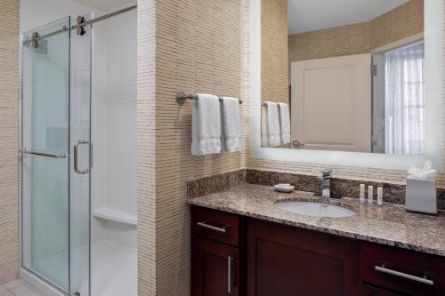 辛辛那提辛辛那提市中心原住客栈酒店的浴室配有盥洗盆和带镜子的淋浴
