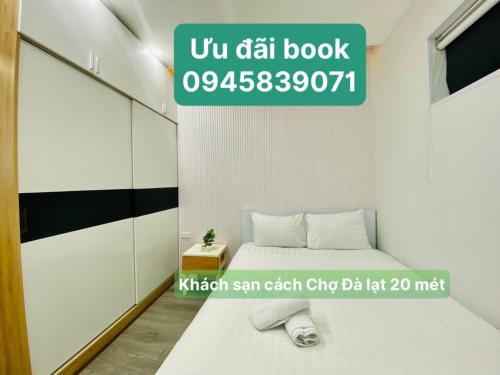 大叻Khách Sạn DaLatView - Cách Chợ Đà Lạt Chỉ 20mét的一间卧室,配有一张床和一个读乌迪尔书的标志