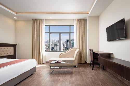 金边HM Grand Central Hotel的酒店客房配有一张床、一张书桌和一台电视。
