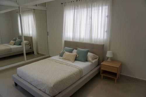 圣多明各Hermoso Apartamento Cerca de la Embajada Americana的一间卧室配有一张大床和镜子