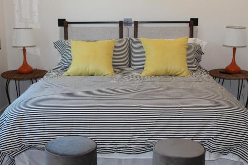 布雷登顿Florida Short and Seasonal townhouses的一张带黑白条纹床单和黄色枕头的床