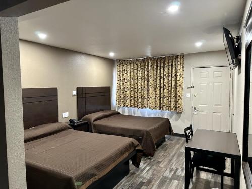 弗拉格斯塔夫Hotel West Inn NAU - Downtown Flagstaff的酒店客房设有两张床和窗户。