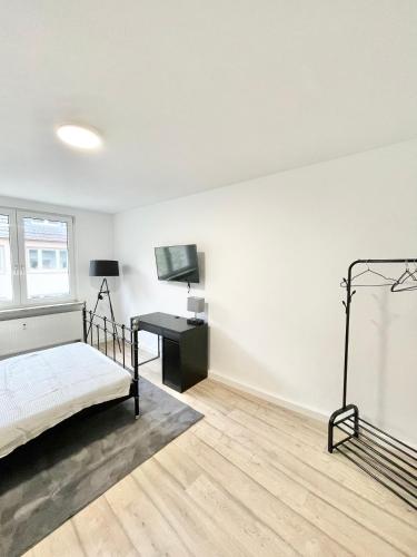 威斯巴登City Loft in Toplage Mainz-Kastel的白色卧室配有床和书桌