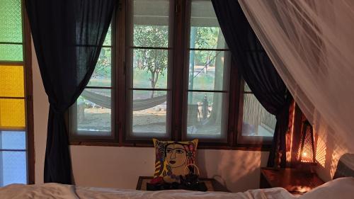 西塔努Cassiopeia Srithanu Apartments的一间卧室设有一张床和两个窗户。