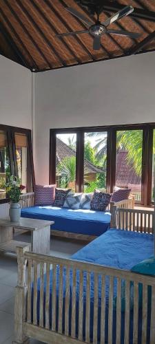 塞莱马德加Villa Gede Private Guest House的一间卧室配有两张床,房间设有长凳