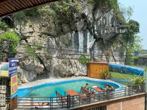 宁平Bamboo Hill Villa的岩石墙前的游泳池