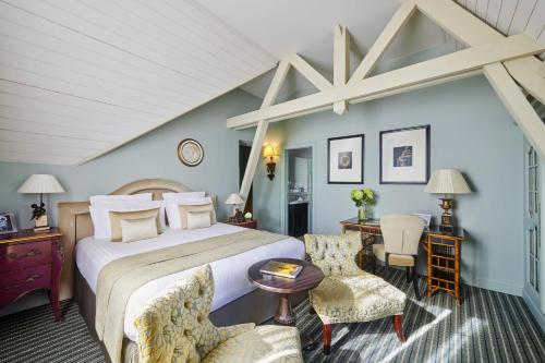 圣艾米隆格兰德巴拉伊城堡度假温泉酒店的一间卧室配有一张特大号床和椅子