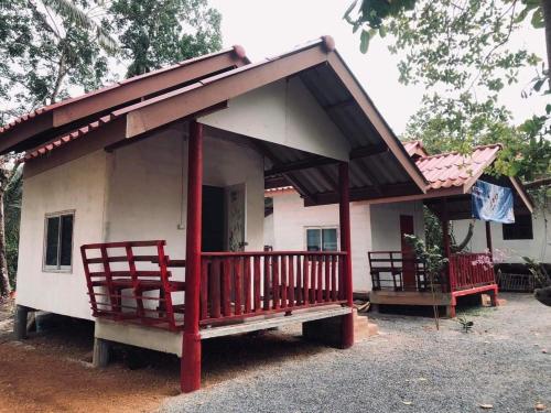 Ban BoGarden Home, Chanthaburi的白色的小房子,设有门廊和两把椅子