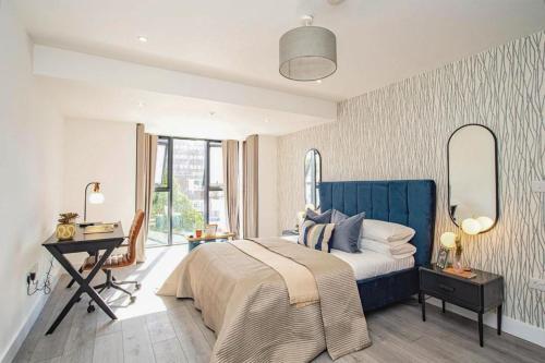 赫默尔亨普斯特德Hemel Apartments- Elite Escape的一间卧室配有一张床、一张书桌和一面镜子