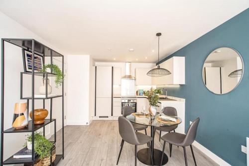 赫默尔亨普斯特德Hemel Apartments- Elite Escape的厨房以及带桌椅的用餐室。