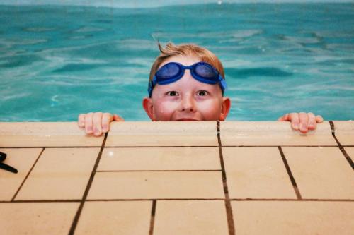 维纳什堡瓦纳斯堡品质酒店的头上戴着眼镜的游泳池里的男孩