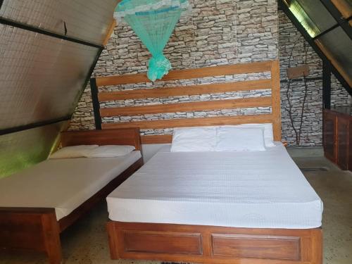 阿努拉德普勒Monara Arana Farm Resort的一间卧室设有两张床和砖墙