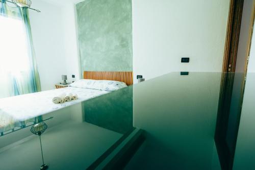 西尼斯科拉Casa Murru的浴室设有床铺和玻璃淋浴间。