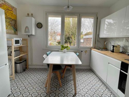 里尔La chambre jaune maison avec grande terrasse et garage privé的一个带桌子和窗户的小厨房