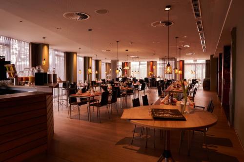 罗斯托克体育论坛酒店的一间在房间内配有桌椅的餐厅