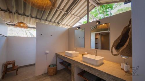 Ban Huai ThawaiElephant View Camp的一间带两个盥洗盆和大镜子的浴室
