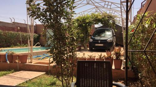 穆罕默迪耶Villa à la compagne的停泊在带游泳池的花园中的汽车